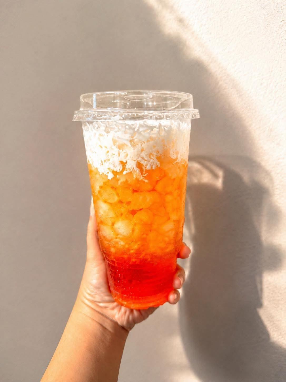 Drink layered with popping boba and coconut flakes